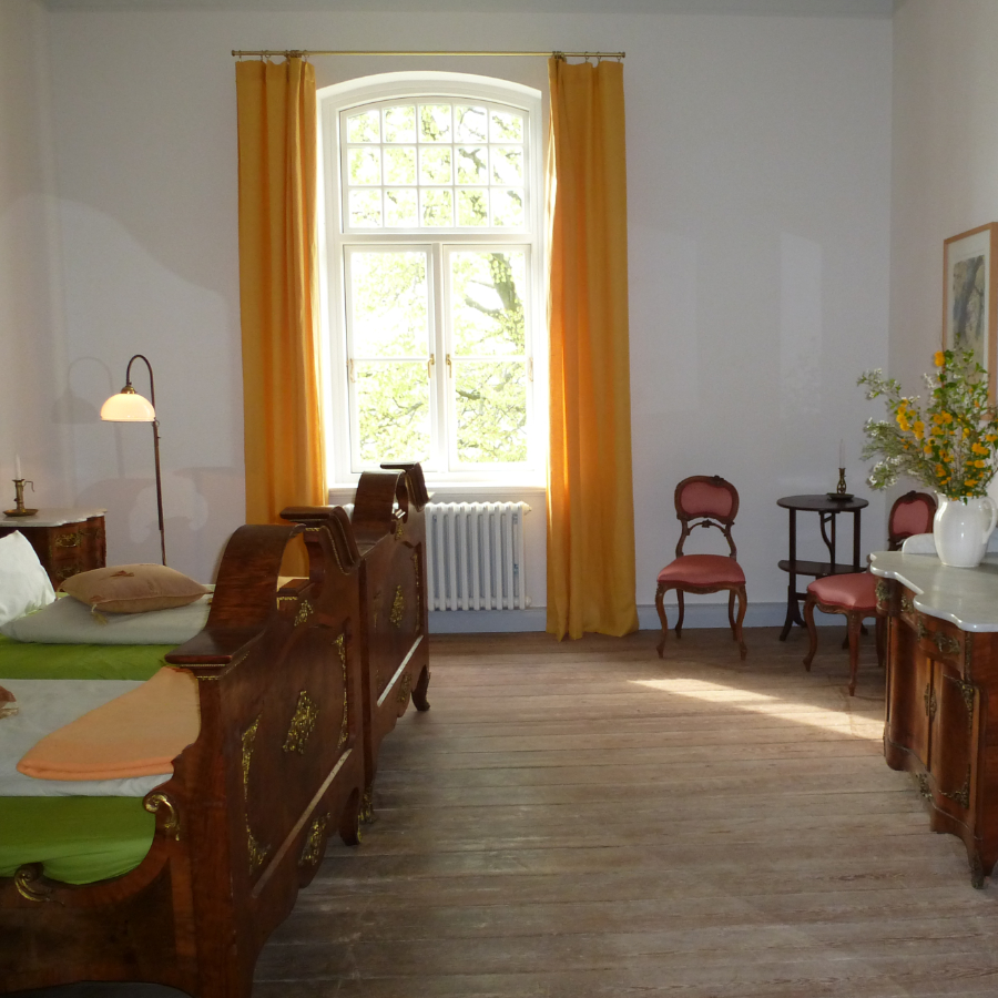 Grosses Zimmer mit altem Doppelbett auf Gut Wittmoldt