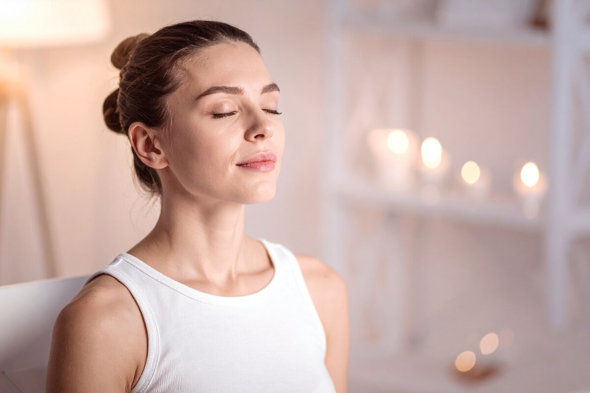 Frau sitzt mit geschlossenen Augen da, um in ihren Körper hineinzustürzen.