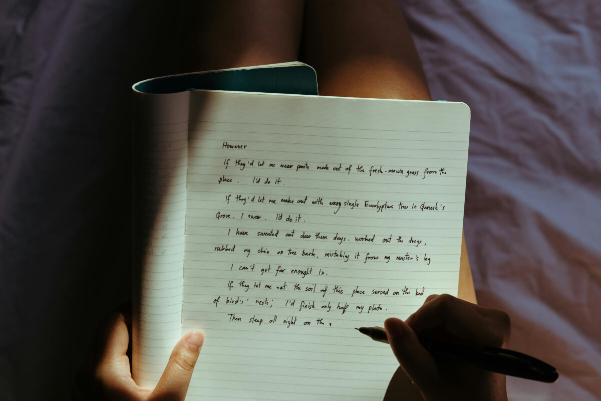 Frau schreibt ihre Gedanken und Gefühle in ein Tagebuch