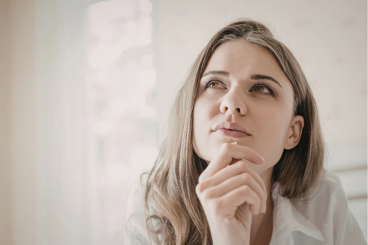 Frau blickt nachdenklich mit Blick nach oben.